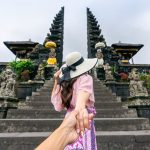Destinations women tourists holding man's hand and leading him to besakih tem