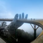 Destinations Golden Bridge in Vietnam with its iconic hand sculpture enveloped in foggy ambiance.